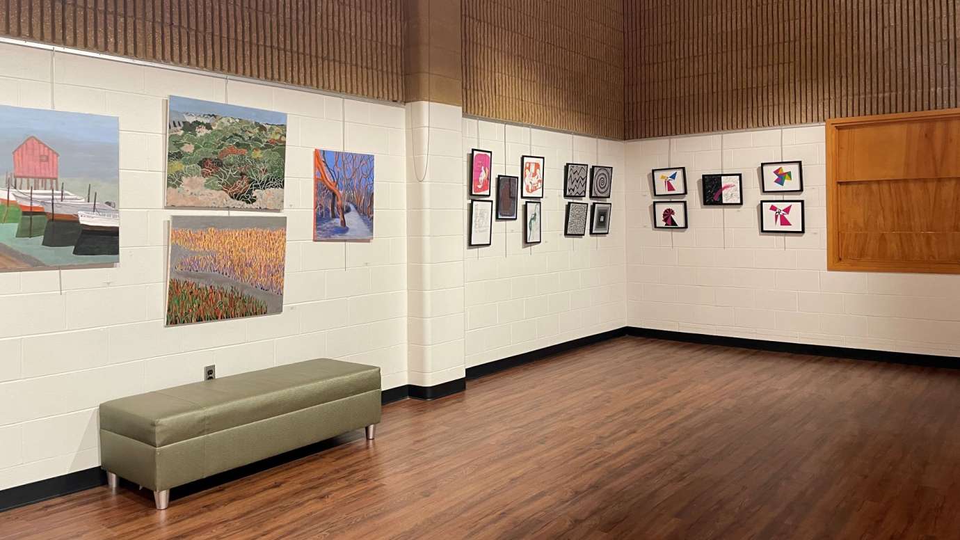 View of gallery walls with colorful paintings