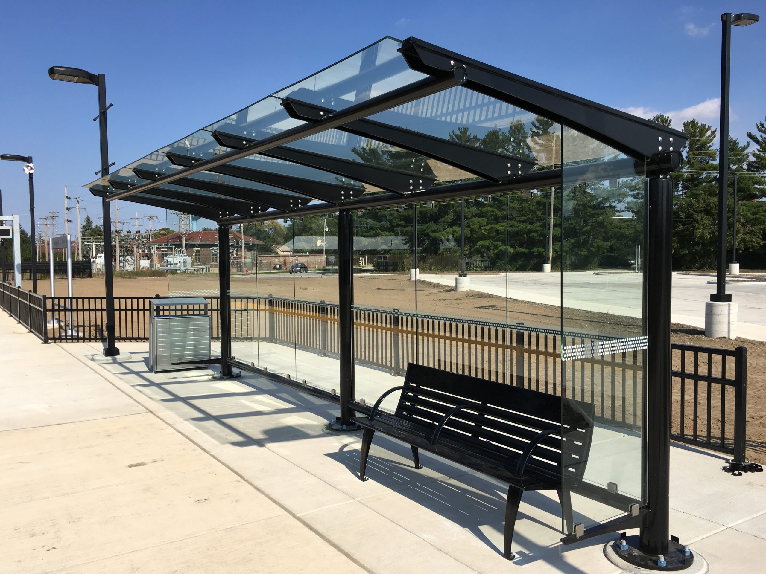 Glass transit stop with black bench