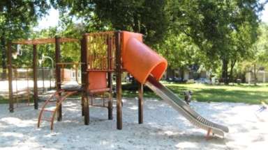 Slides and wooden climbing structure in sandbox at Caraleigh Park