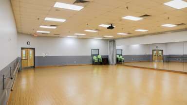 Amenities include a hardwood floor, full length mirrors (with curtain closure), ballet barres, surround sound speakers with CD & IPod capabilities, large screen and ceiling mount projector with Blue Ray capabilities
