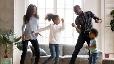 Family dancing in house having fun