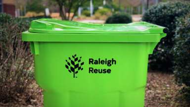 bright green yard waste container with the words &quot;Raleigh Reuse&quot; heat-stamped on the side.