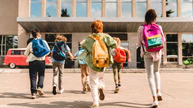 Children with backpacks walking into school