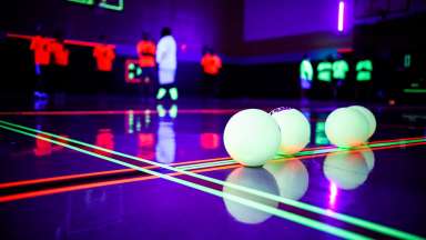 Dodgeballs on a glow-in-the-dark gymnasium floor