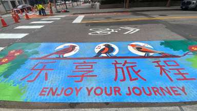 Artwork stating &quot;enjoy your journey&quot; is placed on a Raleigh curb extension