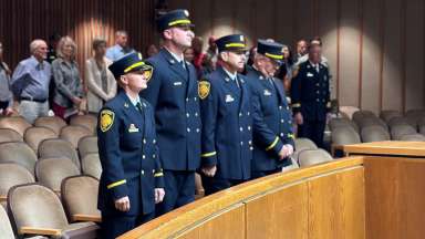 Fire department employees standing to receive promotions