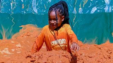 young girl on mud slide