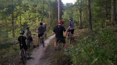 an instructor and children participants on a trail riding mountain bikes