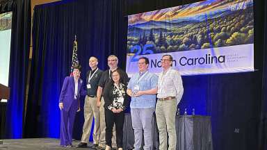 City IT employees on stage receiving an award during a conference.