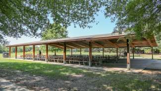A very large picnic shelter with several tables located near the restrooms at Anderson Point Park