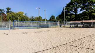 Two of the outdoor sand volleyball courts with lightning at Green Road Park 