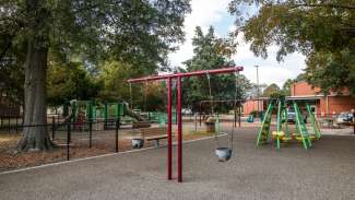 A playground at Method Road Park with swings, slides, climbing equipment and more