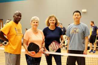 A group of adults playing pickleball