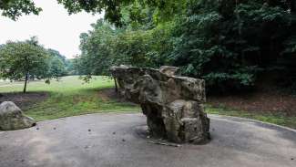 A large boulder used for climbing, with different sides for different difficulty levels
