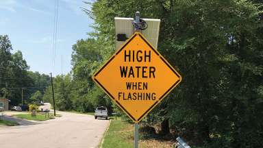 A yellow sign that warns people that a road is flooded