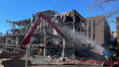 large equipment taking down inner walls of the old police station, photo taken from McDowell St side of building