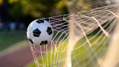 a soccer ball going into a net as a goal