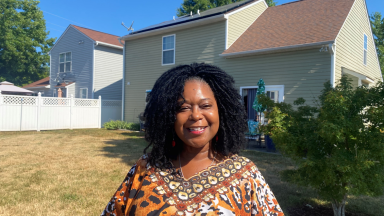 Raleigh resident stands in front of home with rooftop solar