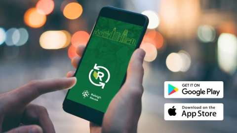 A person holds a smartphone showing the Raleigh Reuse app.