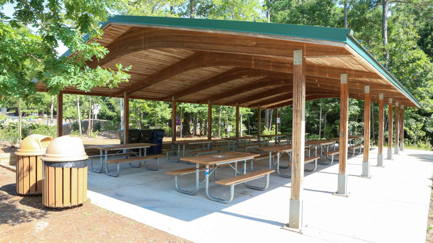 An outdoor picnic shelter with 10 tables