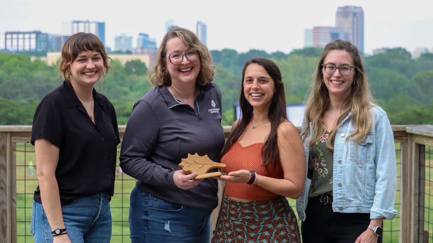 Four members of Office of Sustainability and Solarize the Triangle pose with the award