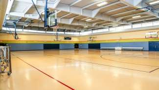 A large open gymnasium at Carolina Pines park with multiple basketball hoops
