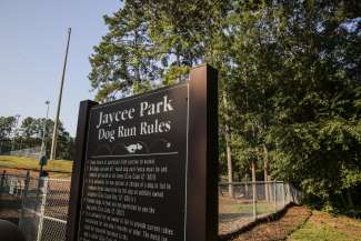 The sign at the entrance to the dog run with the rules