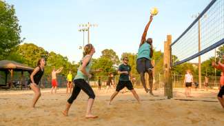A group of young adults playing sand volleyball at Jaycee Park