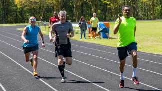 Three active adults racing on a track