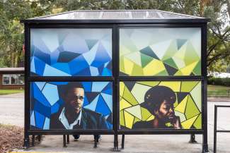 Bus shelter wrapped in art by Kiara Sanders titled "Nina, a Monk, and a Trane". Located at Pecan Road at S. Saunders St.
