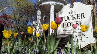 exterior of the Historic Tucker house in the spring with flowers blooming