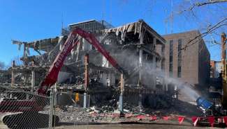 large equipment taking down inner walls of the old police station, photo taken from McDowell St side of building  