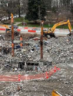 Civic Tower construction site, showing large backhoe and rubble and a small bit of the basement 